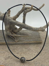 Load image into Gallery viewer, Very large stunning Tahitian South Sea pearl featured on black leather with a stainless steel magnetic clasp and rondels either side of the pearl.
This pearl is Round, 15.5mm in size and dark green with a chocolate color hue to it.
It has light natural birthmarks which add to its character.
The necklet is 52cm in length so perfect as a unisex necklet.
J3571