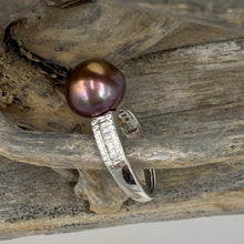 Load image into Gallery viewer, There is only one of these and the size is adjustable.
This exquisite ring features a superb Round 12mm Freshwater pearl that is a natural Chocolate color with Gold hues.
It is just divine with baget cut white cubic zirconia set along both shoulders of this 925 Sterling Silver, non tarnish finish ring
Size is adjustable