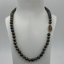 Load image into Gallery viewer, This glamourous Black Freshwater pearl strand features dark round pearls with Green and Purple hues, 8-8.5mm in size.
The highlight is the intricate goddess like Rose Gold and Sterling silver clasp that is a feature of this strand and designed to be worn to see.
Total length including clasp is 48cm