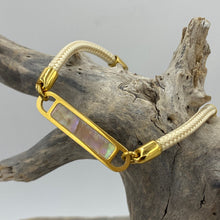 Load image into Gallery viewer, This stunning rope Mother of Pearl shell bracelet with Ivory rope and Gold fittings is the perfect bracelet for a touch of glowing shell teamed with the classy rope and durability of stainless steel setting around the pearl shell
One size
Also available in other colors
Mix and match or stack with other Pig and Hen bracelets 
