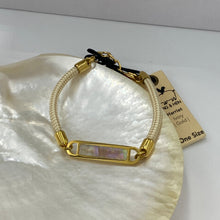 Load image into Gallery viewer, This stunning rope Mother of Pearl shell bracelet with Ivory rope and Gold fittings is the perfect bracelet for a touch of glowing shell teamed with the classy rope and durability of stainless steel setting around the pearl shell
One size
Also available in other colors
Mix and match or stack with other Pig and Hen bracelets 