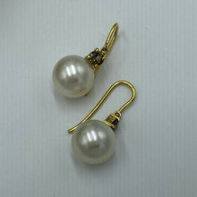 Load image into Gallery viewer, Unique handcrafted 18ct yellow gold hook style earrings featuring Australian South Sea pearls and Claw set natural 'Andalusite' stones that have a Champagne to Green hue.  These stones are Round cut and 4mm in size, the two stones have a total weight 0.5ct  The pearls are Australian South Sea or ocean pearls and are AAA grade in skin and lustre. They are 11.2mm in size, Round in shape and Cream with subtle champagne  hues in color  J3089