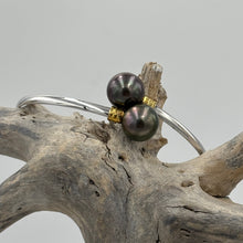 Load image into Gallery viewer, This double pearl bangle is unique with its Sterling Silver bangle featuring a gold plated rib at each pearl. The pearls are Round in shape, 11mm in size and are a natural unique Aubergine in color. They both have Good lustre.
It is featured on this non tarnish wrap bangle
J3515