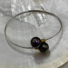 Load image into Gallery viewer, This double pearl bangle is unique with its Sterling Silver bangle featuring a gold plated rib at each pearl. The pearls are Round in shape, 11mm in size and are a natural unique Aubergine in color. They both have Good lustre.
It is featured on this non tarnish wrap bangle
J3515