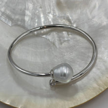 Load image into Gallery viewer, Sterling Silver solid bangle featuring an Australian South Sea Pearl and a bezel set cubic zirconia at either end
This stunning pearl is an Australian South Sea pearl, Circle Drop in shape and 13.8 x 15mm in size. It has high lustre and light natural birthmarks
It is White with Silver Pink hues and is featured on this non tarnish wrap bangle
J3508