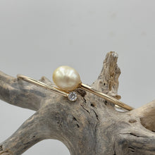 Load image into Gallery viewer, Rose gold plated over Sterling Silver solid bangle featuring a Champagne South Sea Pearl and a bezel set cubic zirconia at either end
This soothing natural Champagne color pearl is an Australian South Sea pearl, Drop in shape and 11.5 x 13.5mm in size. It has good lustre and light natural birthmarks
It is featured on this non tarnish wrap bangle
J3507