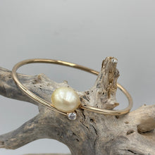 Load image into Gallery viewer, Rose gold plated over Sterling Silver solid bangle featuring a Champagne South Sea Pearl and a bezel set cubic zirconia at either end
This soothing natural Champagne color pearl is an Australian South Sea pearl, Drop in shape and 11.5 x 13.5mm in size. It has good lustre and light natural birthmarks
It is featured on this non tarnish wrap bangle
J3507