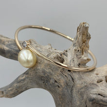 Load image into Gallery viewer, Rose gold plated over Sterling Silver solid bangle featuring a Champagne South Sea Pearl and a bezel set cubic zirconia at either end
This soothing natural Champagne color pearl is an Australian South Sea pearl, Drop in shape and 11.5 x 13.5mm in size. It has good lustre and light natural birthmarks
It is featured on this non tarnish wrap bangle
J3507