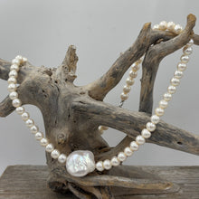 Load image into Gallery viewer, This unusual Freshwater pearl necklace/ strand features 6.5mm white Button shape pearls unknotted, with a central feature of a flattish baroque pearl, white with rainbow hues and 18.5 x 19.5mm in size and high lustre
It has a 925 sterling silver Cartier or lobster clasp
The total length including clasp is 43cm