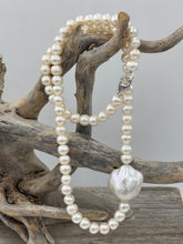 Load image into Gallery viewer, This unusual Freshwater pearl necklace/ strand features 6.5mm white Button shape pearls unknotted, with a central feature of a flattish baroque pearl, white with rainbow hues and 18.5 x 19.5mm in size and high lustre
It has a 925 sterling silver Cartier or lobster clasp
The total length including clasp is 43cm