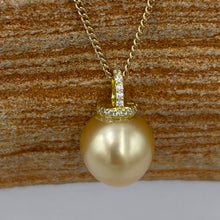 Load image into Gallery viewer, This Golden South Sea pearl pendant is set on gold plated 925 Sterling silver encrusted with cubic zirconia for a sparkly finish.
The pearl is Drop in shape, 11.8 x 12.2mm and is a Deep Gold with subtle apricot hues.
The lustre is Excellent and it has flawless skin
Chain included is Base metal only
J3289