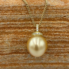 Load image into Gallery viewer, This Golden South Sea pearl pendant is set on gold plated 925 Sterling silver encrusted with cubic zirconia for a sparkly finish.
The pearl is Drop in shape, 11.8 x 12.2mm and is a Deep Gold with subtle apricot hues.
The lustre is Excellent and it has flawless skin
Chain included is Base metal only
J3289