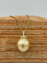 Load image into Gallery viewer, This Golden South Sea pearl pendant is set on gold plated 925 Sterling silver encrusted with cubic zirconia for a sparkly finish.
The pearl is Drop in shape, 11.8 x 12.2mm and is a Deep Gold with subtle apricot hues.
The lustre is Excellent and it has flawless skin
Chain included is Base metal only
J3289
