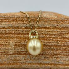 Load image into Gallery viewer, This Golden South Sea pearl pendant is set on gold plated 925 Sterling silver encrusted with cubic zirconia for a sparkly finish.
The pearl is Drop in shape, 11.8 x 12.2mm and is a Deep Gold with subtle apricot hues.
The lustre is Excellent and it has flawless skin
Chain included is Base metal only
J3289