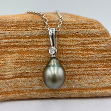Load image into Gallery viewer, This Fijian South Sea pearl pendant enhancer is set on 925 Sterling silver with a bezel set cubic zirconia for added bling.
This pearl is Green in colour with natural Blue hues and is Circle Drop in shape, 11.1 x 14mm in size.
The lustre is good and the skin clean on this pearl
Chain included is Base metal only
J3429