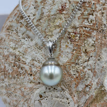 Load image into Gallery viewer, Unusual Fijian South Sea pearl pendant set on a simple 9ct White gold fitting.
This pearl is has a natural 'brown' circle birth mark around it giving a halo effect to the Pastel Blue Grey color of the pearl. It is Drop shape, 10.4 x 13mm in size.
The lustre is good and the skin clean on this pearl
Chain included is Base metal only
J3403