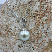 Load image into Gallery viewer, Unusual Fijian South Sea pearl pendant set on a simple 9ct White gold fitting.
This pearl is has a natural 'brown' circle birth mark around it giving a halo effect to the Pastel Blue Grey color of the pearl. It is Drop shape, 10.4 x 13mm in size.
The lustre is good and the skin clean on this pearl
Chain included is Base metal only
J3403