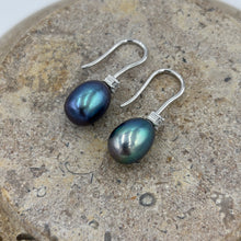 Load image into Gallery viewer, These elegant and classic Hook earrings are Sterling Silver and rhodium coated for a non tarnish finish and they feature a single claw set cubic zirconia above each pearl.
The pearls are drop shape, 9 x 12mm in size and Green with peacock hues in colour.
Also available with White or Pink pearls to order