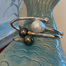 Load image into Gallery viewer, This double pearl bangle is unique with its Sterling Silver bangle featuring a gold plated rib at each pearl. The pearls are Round in shape, 11mm in size and are a natural unique Aubergine in color. They both have Good lustre.
It is featured on this non tarnish wrap bangle
J3515