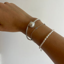 Load image into Gallery viewer, Sterling Silver solid bangle featuring an Australian South Sea Pearl and a bezel set cubic zirconia at either end
This stunning pearl is an Australian South Sea pearl, Circle Drop in shape and 13.8 x 15mm in size. It has high lustre and light natural birthmarks
It is White with Silver Pink hues and is featured on this non tarnish wrap bangle
J3508