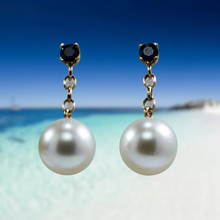 Load image into Gallery viewer, Stunning handcrafted 9ct yellow gold earrings featuring studs of Blue sapphires, 4mm round and claw set. Under this is 9ct chain joining to our highest grade White South Sea Pearls. They are 11.4mm, Round in shape White with pink hues, AAA grade lustre and skin