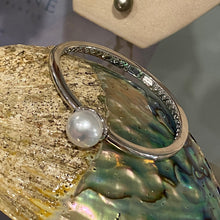 Load image into Gallery viewer, Sterling Silver solid bangle featuring an Australian South Sea Pearl
This stunning pearl is an Australian South Sea pearl, Button in shape and 14.3mm in size. It is White with Silver Pink hues and is featured on this rhodiun coated non tarnish bangle
J3293