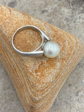 Load image into Gallery viewer, &#39;Anthea&#39; is an Australian South Sea Pearl ring with high shoulders and a sleek design for pearl protection and easy wear.

It features a Round 10.3mm pearl with white cream tones set on a 925 sterling silver ring that is rhodium coated for a non tarnish finish.

This pearl has Good lustre and light natural &#39;birthmarks&#39;

Size N1/2

J3550
