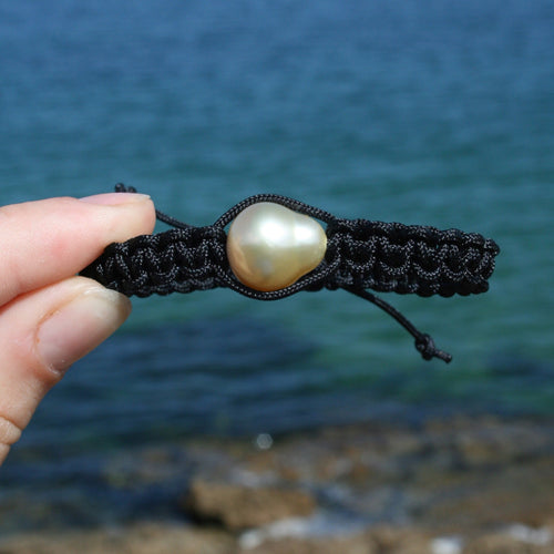 Thick Black Macrame bracelet featuring an Indonesian South Sea Pearl, Circle Drop in shape, 13.2 x 14.8mm in size, Gold in colour, high lustre and clean skin.  (J3317)  This bracelet is made from water and colorfast nylon material for heavy duty wear and tear, features no glue and no metal parts   
