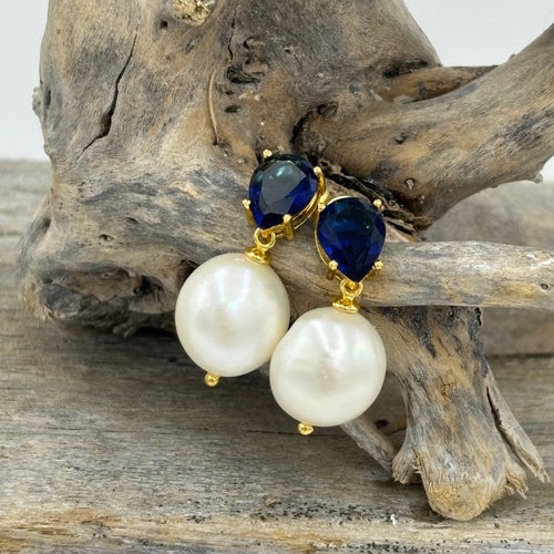 These fabulous stud style earrings are made of 18K gold plated over 925 sterling silver and feature a beautiful claw set navy blue cubic zirconia with a button shape white pearl.

The pearls measure 11-12mm.

The size from top to bottom is 24mm.