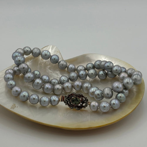 This stunning long Freshwater pearl strand features beautiful Silver Grey round freshwater pearls, 10-11mm in size and a stunning Italian clasp of rose gold over sterling silver..

The clasp is a feature in itself and is designed to be worn at the side

Total length  including clasp is 60cm.