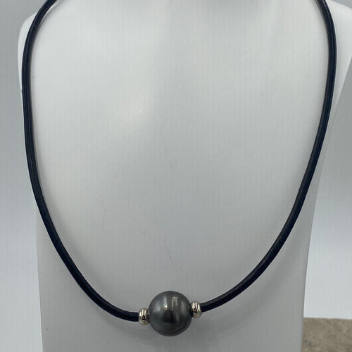 Very large stunning Tahitian South  Sea pearl featured on black leather with a stainless steel magnetic clasp and rondels either side of the pearl.

This pearl is Round, 15.5mm in size and dark green with a chocolate color hue to it.

It has light natural birthmarks which add to its character.

The necklet is 52cm in length so perfect as a unisex necklet.

J3571