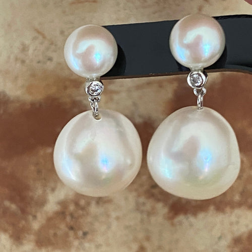 Sterling silver stud style earrings featuring a Small White 8mm Button Pearl on the stud, a small  bezel set Cubic Zirconia and a large White Button shape 13.5 to 14mm Pearl underneath. 