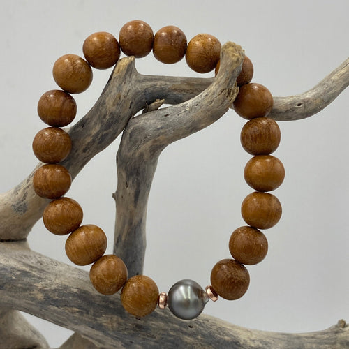  stunning stretch bracelet featuring a beautiful  Fijian South Sea Pearl highlighted by the Sandalwood beads.  The Pearl is Drop in shape, is 10.3mm in size and features shades of  Aubergine .  J3473