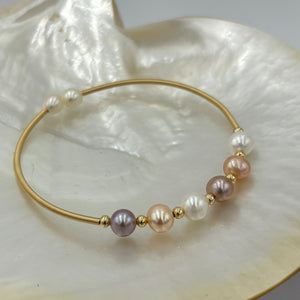 14ct Gold plated Sterling silver wire wrap bracelet featuring a mix of 6 natural white, pink and lavender hue freshwater pearls, round shaped, 7mm in size and 2 smaller white pearls 5.9mm on ends.