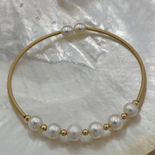 Load image into Gallery viewer, 14ct Gold plated Sterling silver wire wrap bracelet featuring 6 natural white freshwater pearls, round shaped, 7mm in size with 2 smaller white 5.8mm pearls on the ends.
