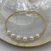 Load image into Gallery viewer, 14ct Gold plated Sterling silver wire wrap bracelet featuring 6 natural white freshwater pearls, round shaped, 7mm in size and 2 smaller white pearls 5.8mm on ends.
