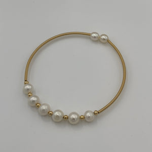 14ct Gold plated Sterling silver wire wrap bracelet featuring 6 natural white freshwater pearls, round shaped, 7mm in size with 2 smaller white 5.8mm pearls on the ends.