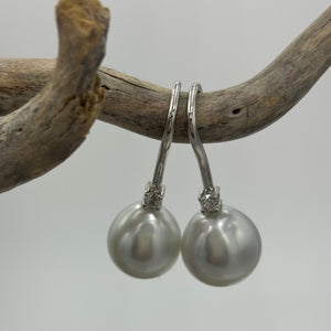 Classic style hook earrings featuring Australian South Sea Pearls on 925 sterling silver set with claw set Cubic Zirconia  They feature Semi Baroque Drop shaped pearls,&nbsp; 11mm x 12mm in size and White with Pink Silver hues in colour.  High lustre  J3461