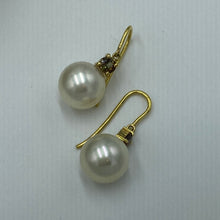 Load image into Gallery viewer, Unique handcrafted 18ct yellow gold hook style earrings featuring Australian South Sea pearls and Claw set natural &#39;Andalusite&#39; stones that have a Champagne to Green hue.  These stones are Round cut and 4mm in size, the two stones have a total weight 0.5ct  The pearls are Australian South Sea or ocean pearls and are AAA grade in skin and lustre. They are 11.2mm in size, Round in shape and Cream with subtle champagne  hues in color  J3089
