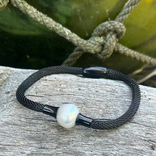 <p>'Mesha' features a black stainless steel mesh bracelet with a white Australian South Sea Pearl</p> <p>Pearl is a button shape, and is 12.2mm in size and is white with silver pink hues in colour</p> <p>This bracelet is made out of stainless steel mesh 4.5mm in size with a magnetic clasp</p> <p>J3363</p>