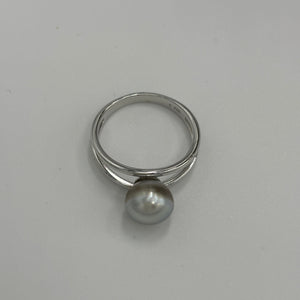 This split band ring features an Abrolhos Islands Australian South Sea Pearl set in 925 sterling silver and rhodium coated for a non tarnish finish.  The pearl is button in shape,&nbsp; and 9.2mm in size and a pastel Grey Blue with Brown hues color . These pastel tones are typical of the pearls grown off the Abrolhols Islands of WA  Size Q / 58  J3436