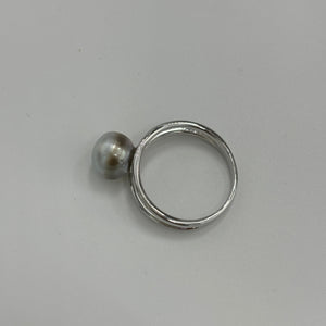 This split band ring features an Abrolhos Islands Australian South Sea Pearl set in 925 sterling silver and rhodium coated for a non tarnish finish.  The pearl is button in shape,&nbsp; and 9.2mm in size and a pastel Grey Blue with Brown hues color . These pastel tones are typical of the pearls grown off the Abrolhols Islands of WA  Size Q / 58  J3436