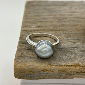 This ring features a Tahitian South Sea Pearl set in&nbsp;925 sterling silver and rhodium coated for a non tarnish finish.  This beautiful Blue pearl is an unusual Baroque Button shape and 10.7mm x 11.2mm in size.  Size P/ 57  J3438