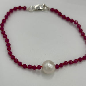 Australian South Sea pearl bracelet with 3mm faceted ruby gemstones and a sterling silver peanut clasp  This stunning deep ruby red bracelet features a single White Australian South Sea pearl, button shape,&nbsp; 9.4mm in size, White in color, with light natural 'birthmarks'  The length including the clasp is 19cm  J3445