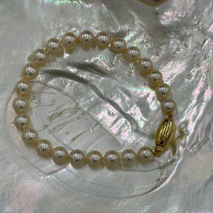 A Timeless and Classic bracelet featuring stunning Akoya Sea pearls.  This bracelet features twenty three round pearls, 7mm- 7.5mm, AAA grade, high lustre pearls of subtle Champagne color.  The clasp is a barrel shape polished 18ct yellow gold clasp.