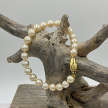 Load image into Gallery viewer, A Timeless and Classic bracelet featuring stunning Akoya Sea pearls.  This bracelet features twenty three round pearls, 7mm- 7.5mm, AAA grade, high lustre pearls of subtle Champagne color.  The clasp is a barrel shape polished 18ct yellow gold clasp.
