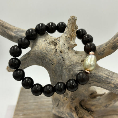 A stunning stretch bracelet featuring a beautiful Golden Fijian South Sea Pearl contrasting with the Black Wooden Beads.  The Pearl is Semi Baroque, 10.2mm x 14mm in size and features champagne colours.  J3471