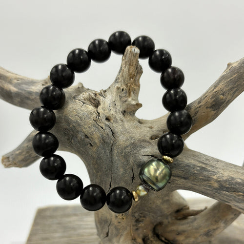 A stunning stretch bracelet featuring a beautiful Peacock Fijian South Sea Pearl highlighted by the Ebony beads.  The Pearl is Circle Drop in shape, is 11.3mm x 14mm in size and features shades of peacock blue and green.  J3474