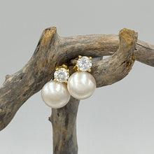 Load image into Gallery viewer, These fabulous stud style earrings are made of 18K gold plated 925 sterling silver. They feature a claw set cubic zirconia with a button shape white freshwater pearl.

The pearls measure 10mm.
