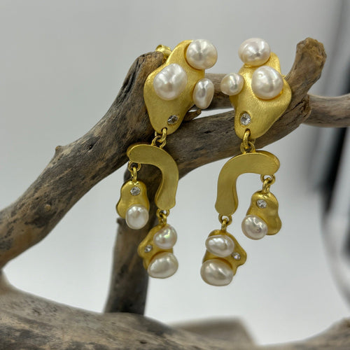 18K gold plated over 925 sterling silver stud style earrings with a satin finish.  Featuring six White Freshwater Rice' shape pearls on each earring, 5-7mm, fragmented over the design, with Cubic Zirconia highlights.  They are 50mm in total length from top to bottom.  Available in silver or gold